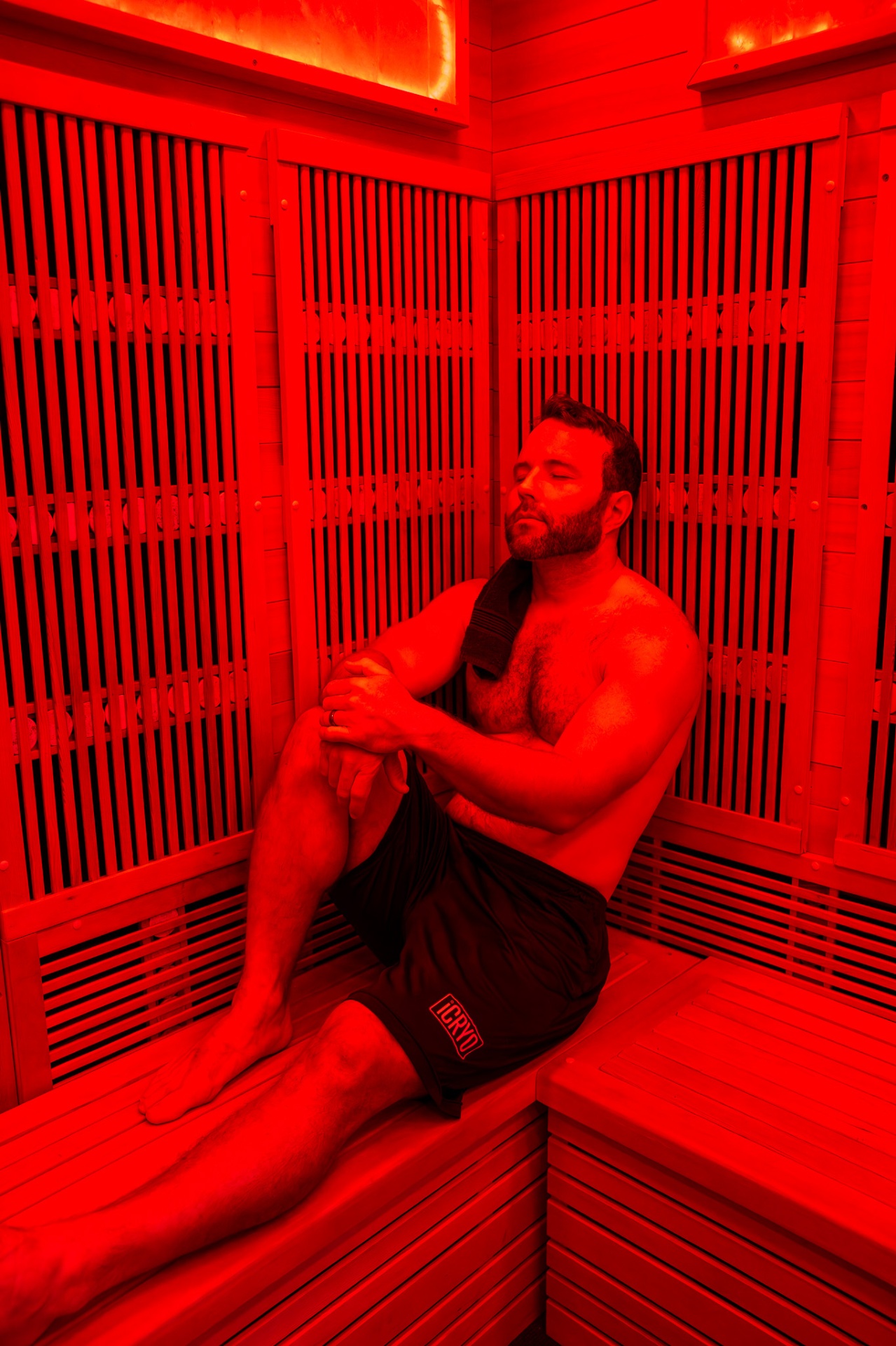 Woman relaxing in infrared sauna with therapeutic red lights